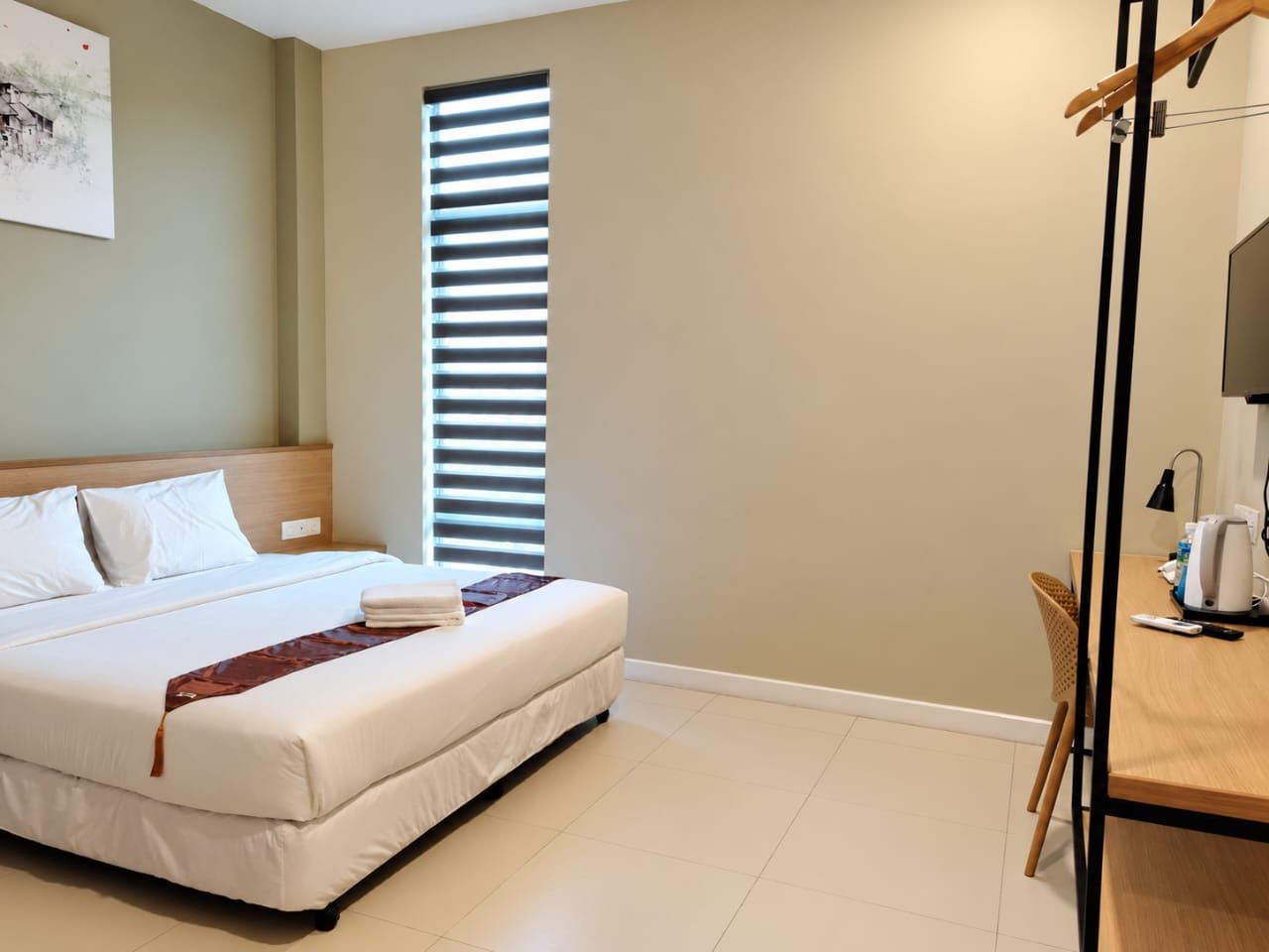Deluxe King room with tall window, desk, kettle and wardrobe rail