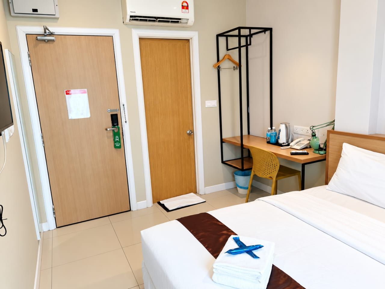 Deluxe Queen room entrance with air-conditioning, desk and wardrobe rail