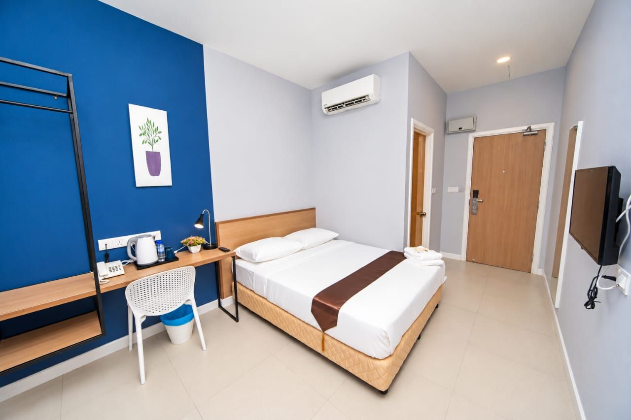 Deluxe Queen room with blue feature wall, desk and wardrobe rail