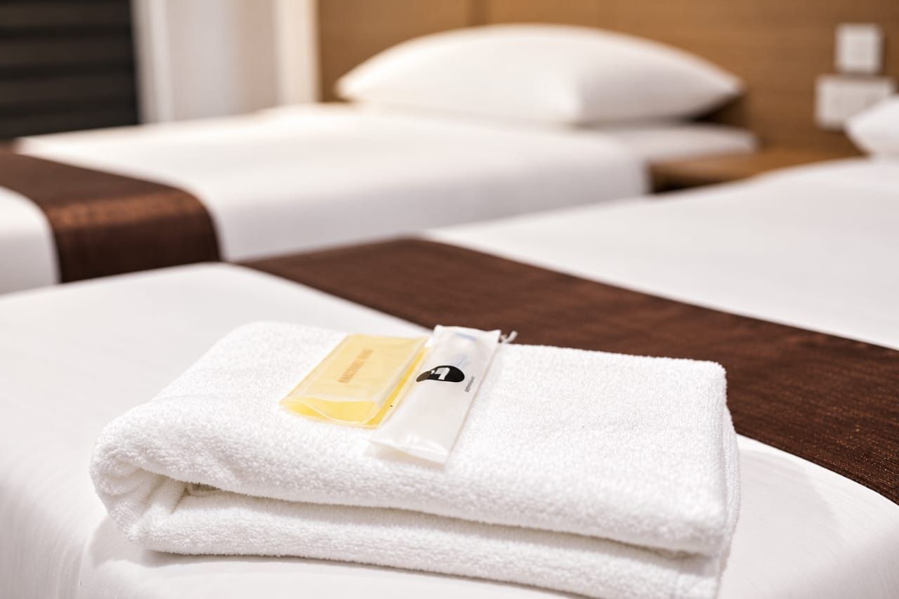 Fresh towel with toiletries on a Deluxe Twin bed