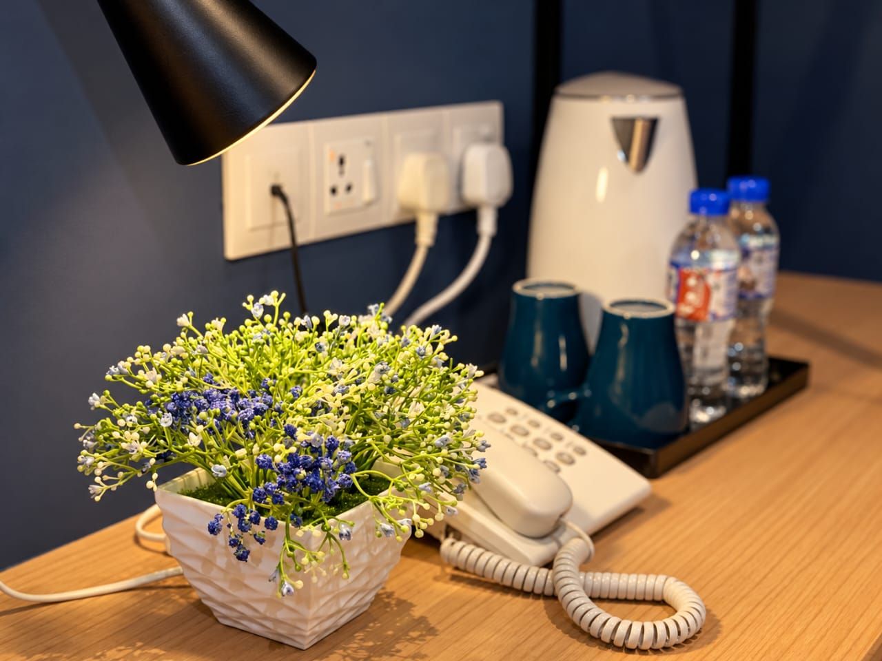 Desk with kettle, bottled water, cups and telephone in a Deluxe Twin room